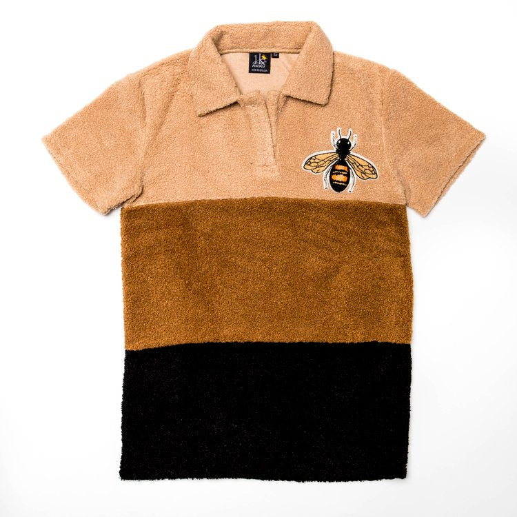 Flat lay view of the 1K Bee Chenille men's polo showing the sand, brown, and black color block design
