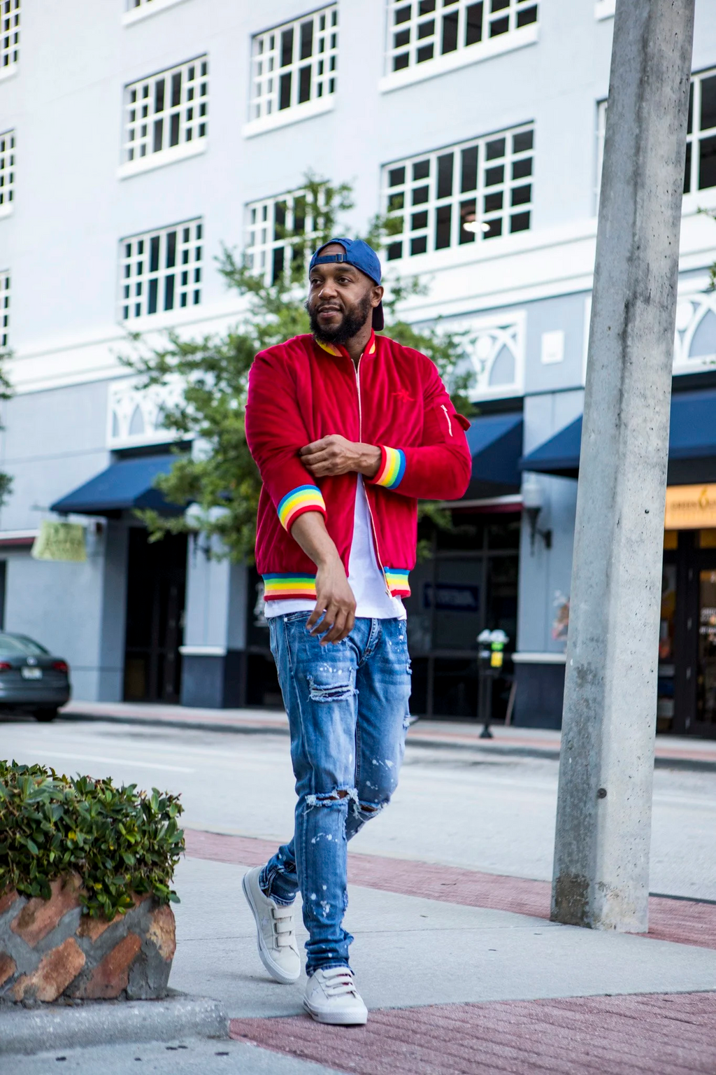 Front view of the 1K Spectrum men's red suede bomber jacket showing the vibrant rainbow trim and premium material