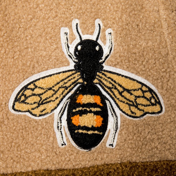Close up of the embroidered bee patch on the 1K Bee Chenille shirt highlighting the detailed gold stitching